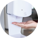 Hand under soap dispenser.
