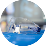 A pair of clear safety glasses on a blue table
