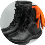 A pair of heavy-duty work safety shoes with an orange glove