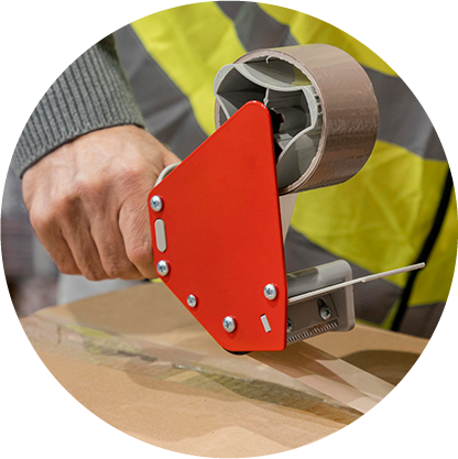 Worker sealing cardboard box with packaging tape dispenser