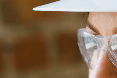 A woman wearing clear safety glasses and a white protection hat