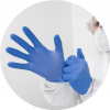 A person equipped with mask and coverall, putting on blue disposable gloves
