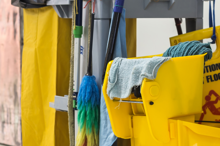 A roller cart with janitorial and cleaning equipment